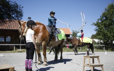 Maja leder Saga och Edvin kastar lasso från hästryggen. Ovanligt hästdagläger juli 2018.